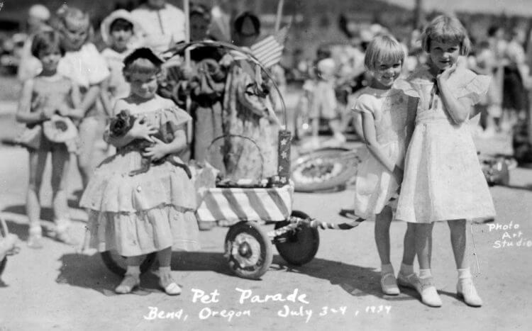 Genevieve Armstrong (with cat) and sister Joyce in the 1934 pet parade. Friend Elma Ramlo accompanies, pulling the wagon.