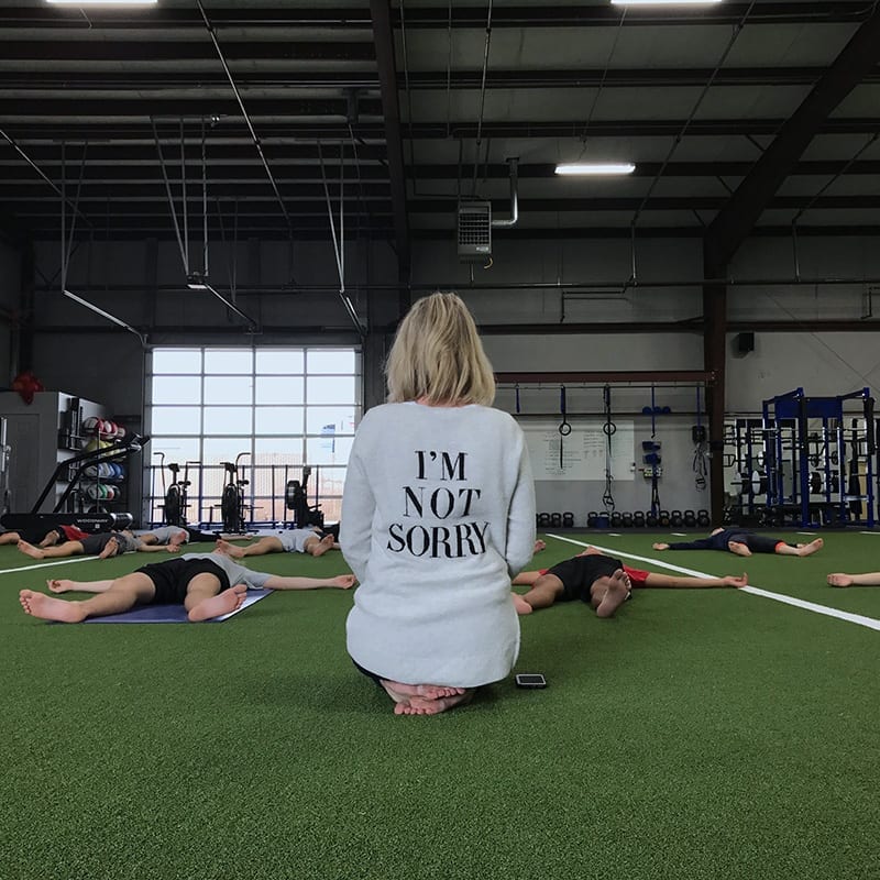 Tracy Treu teaching yoga to a group of high school athletes.