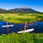 Two girls paddleboarding in Central Oregon