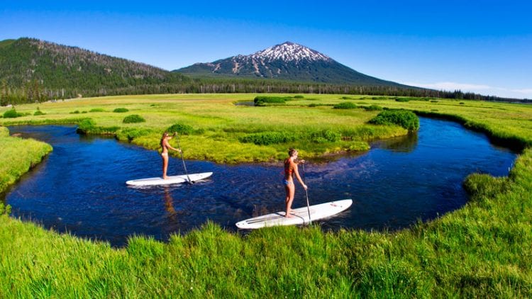 Two girls paddleboarding in Central Oregon
