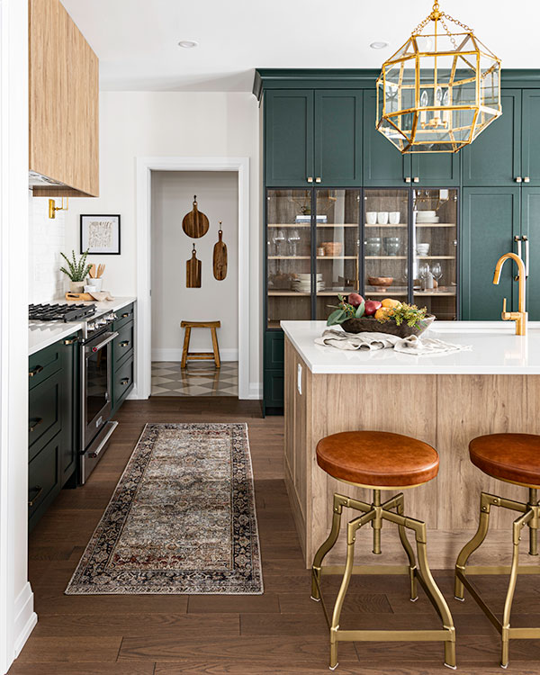 Green kitchen with White Island and leather barstools