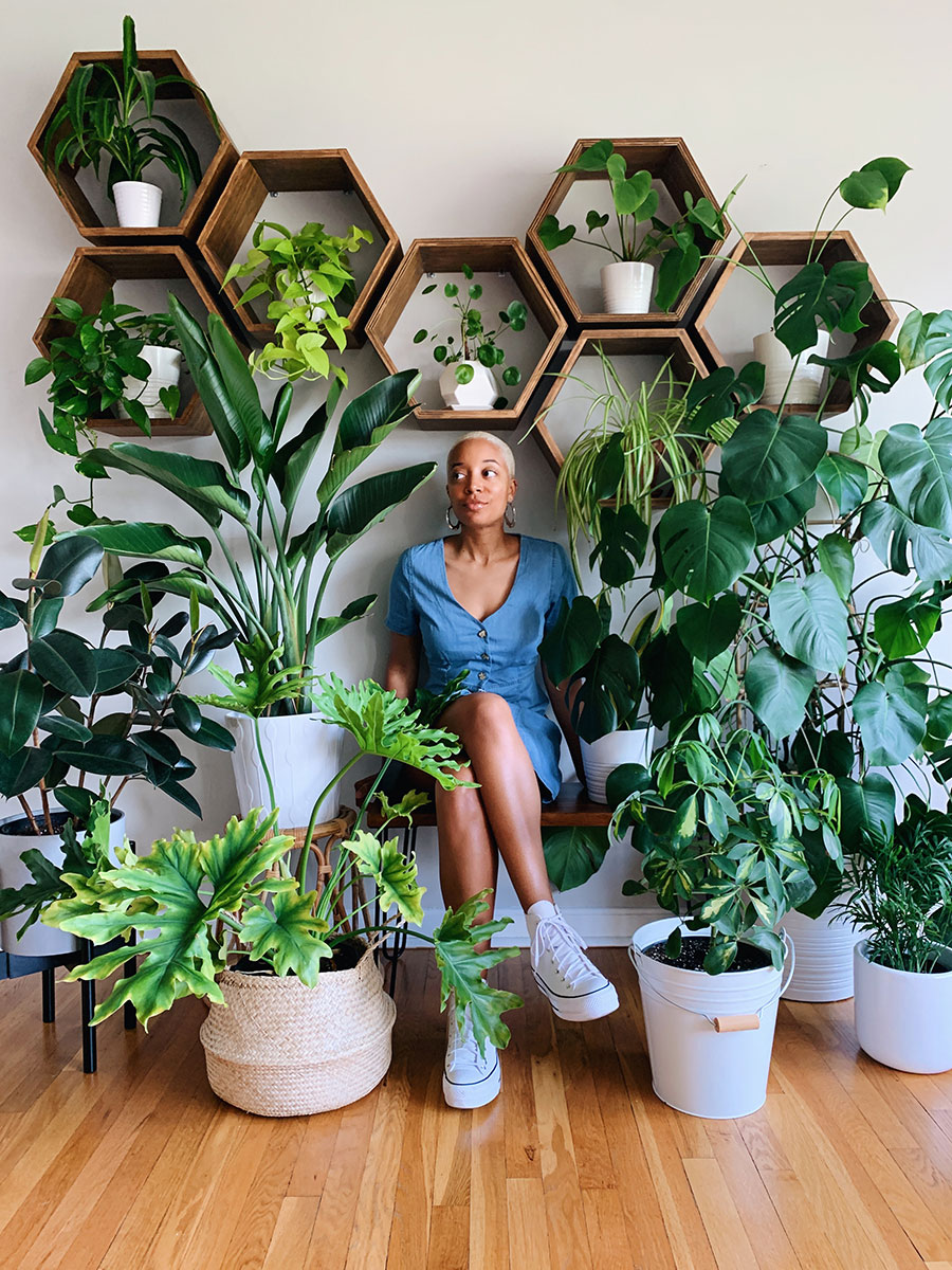 Woman sitting amongst many house plants