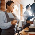 woman employee making coffee at coffee shop