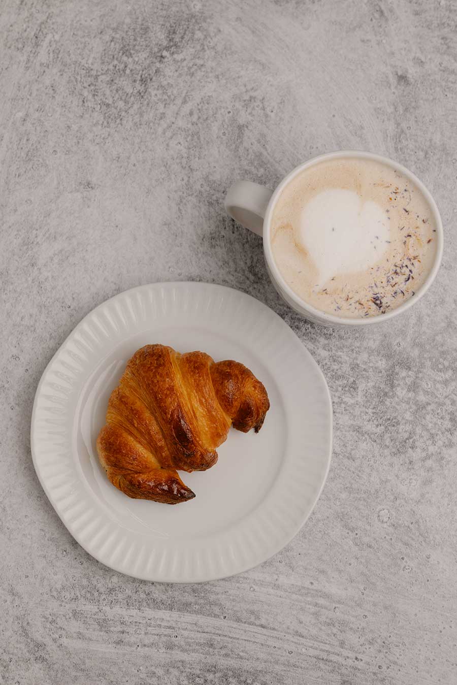 hot lava bakery croissant and latte on table