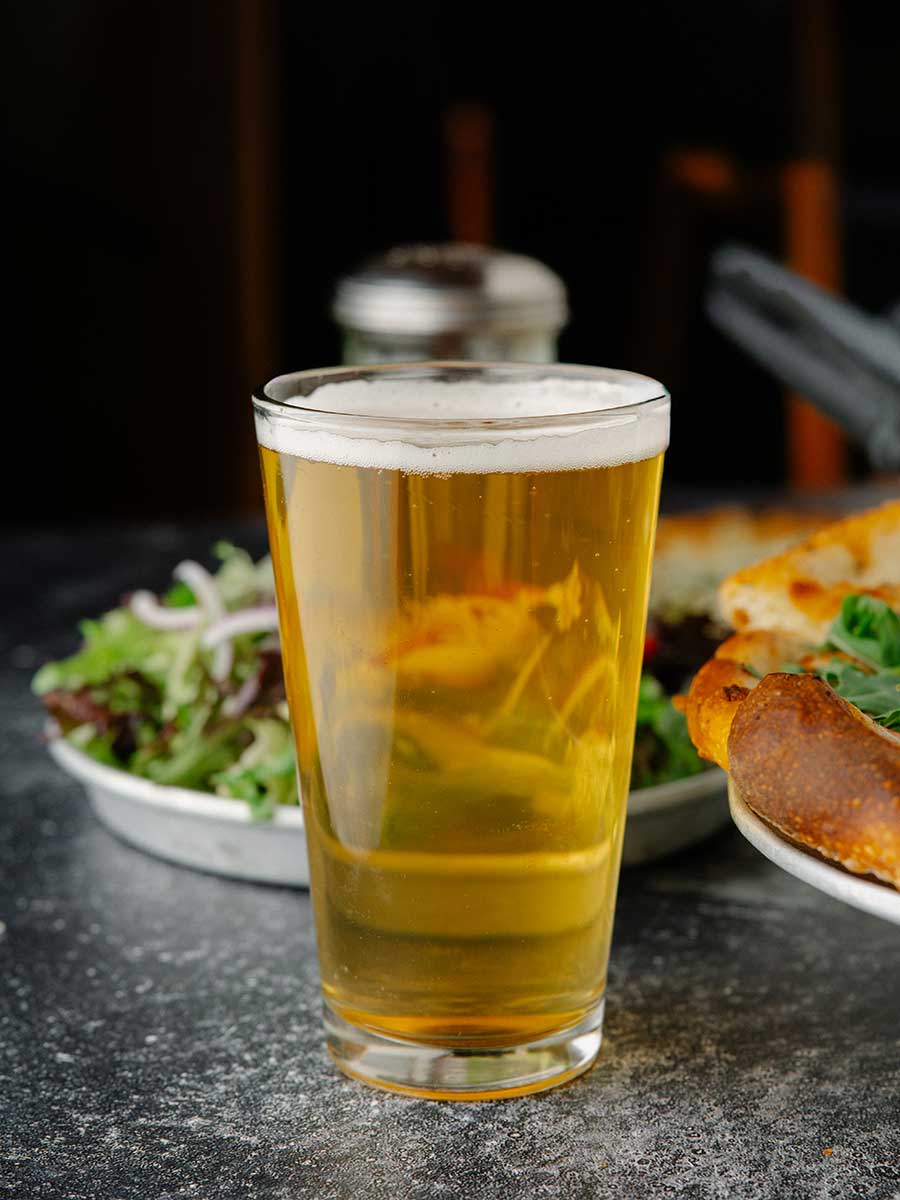 Pizza Mundo beer on table in front of salad