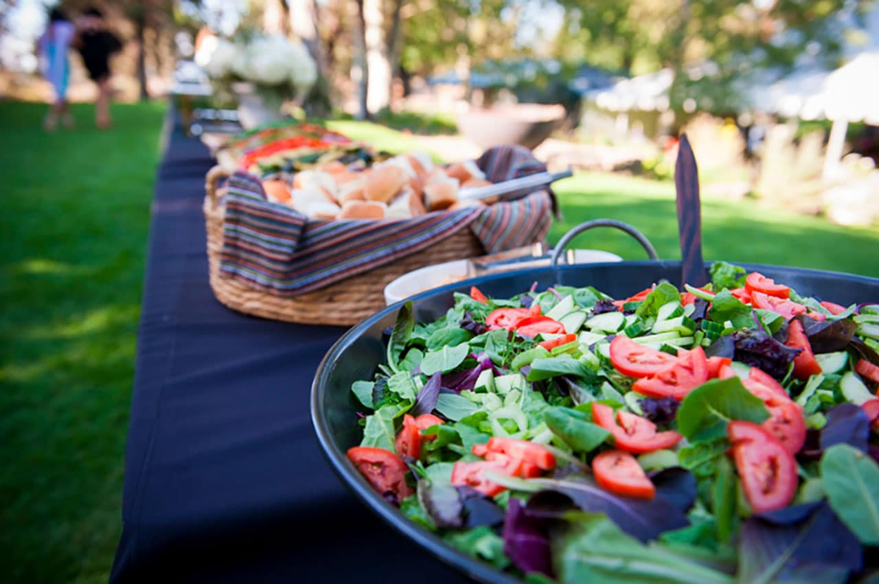 Salad on a table outside, catered by Back to the Tables.