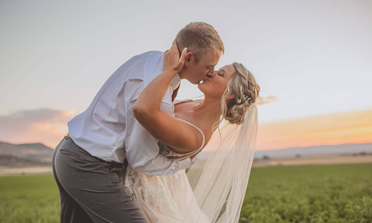 Two people kissing in field