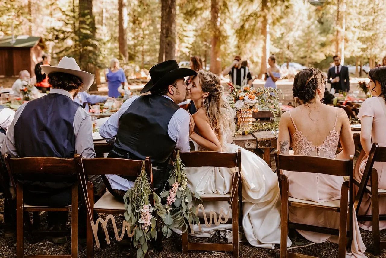 Bride and Groom kissing at outdoor table.