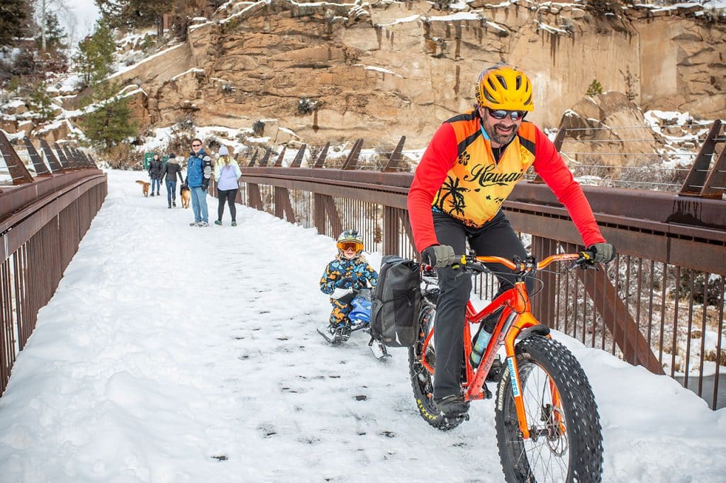 Fat tire biker pulling sled on South Canyon Reach Trail - Deschutes River