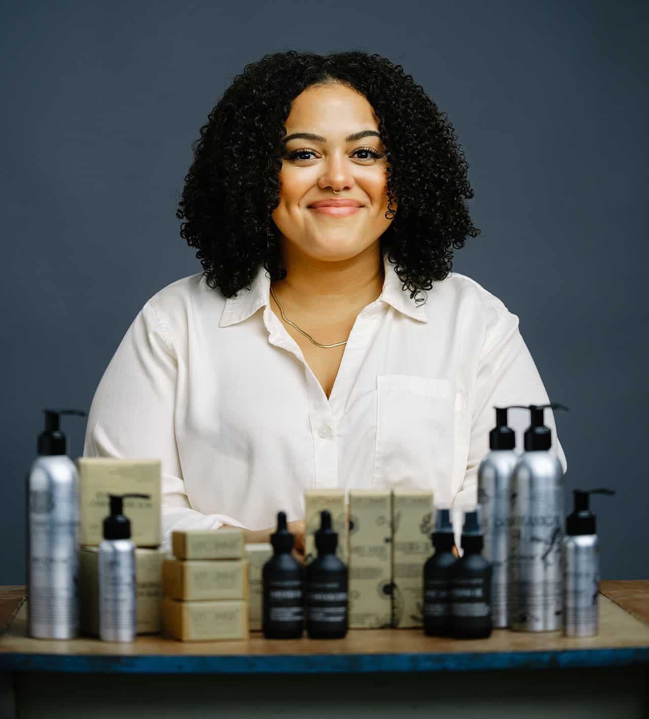 Dominiqe-Taylor with her products, Consciously-Curly Co.