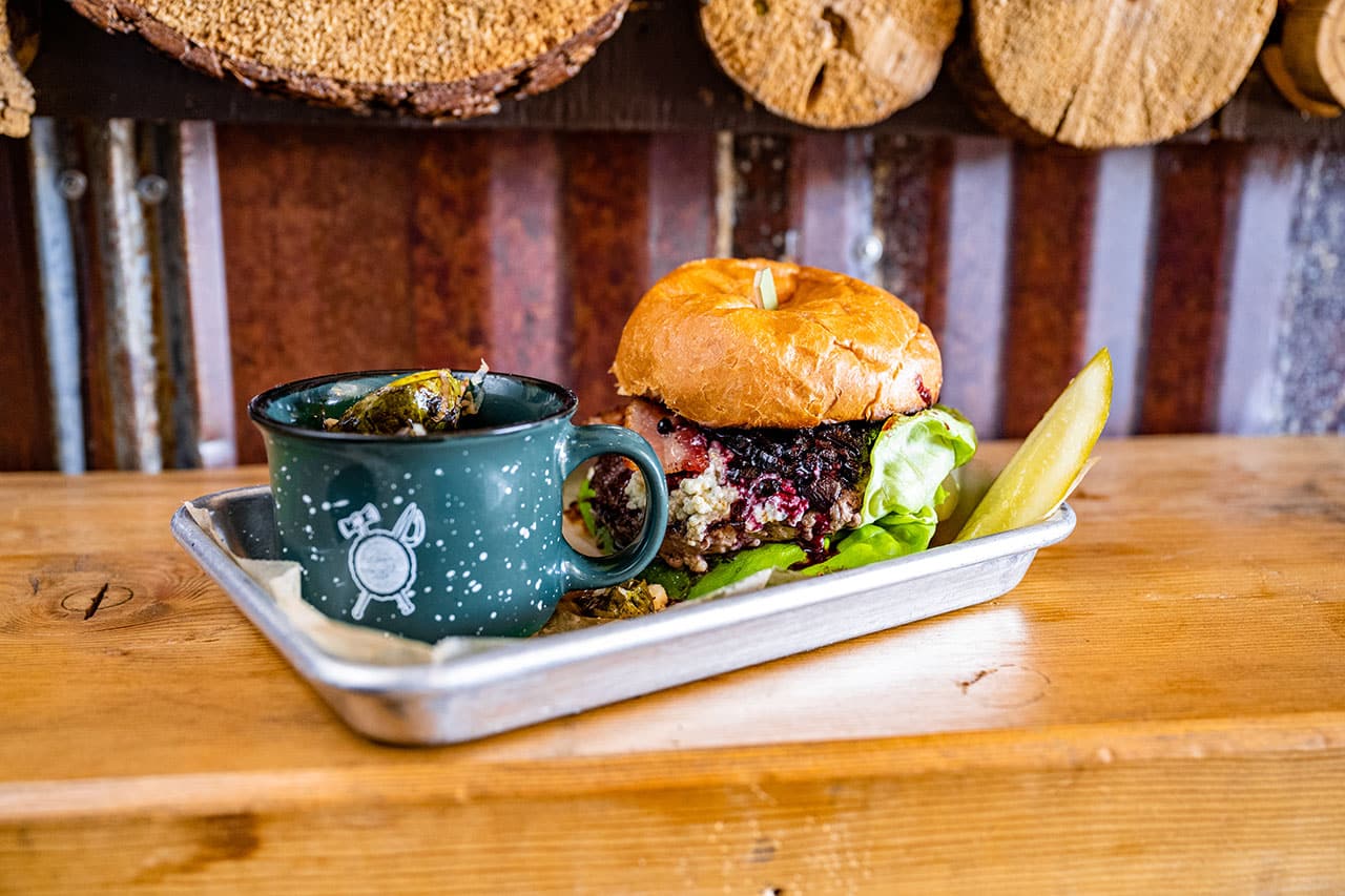 Burger on tray with mug from Luckey's Woodsman