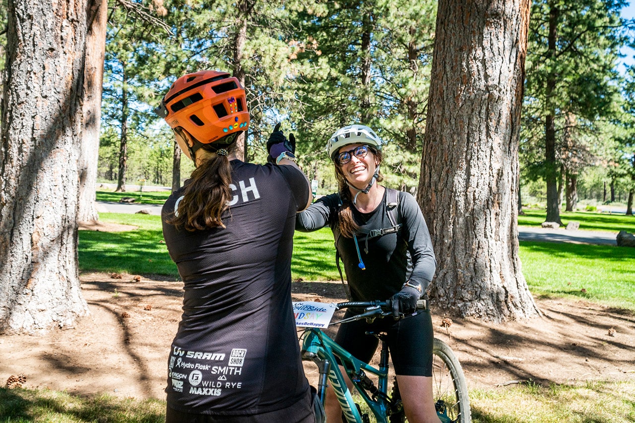 Mountain bikers high five on the trail in Bend