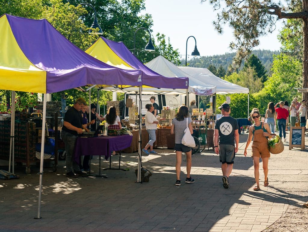 Woman with veggies walking at Bend Farmers Market