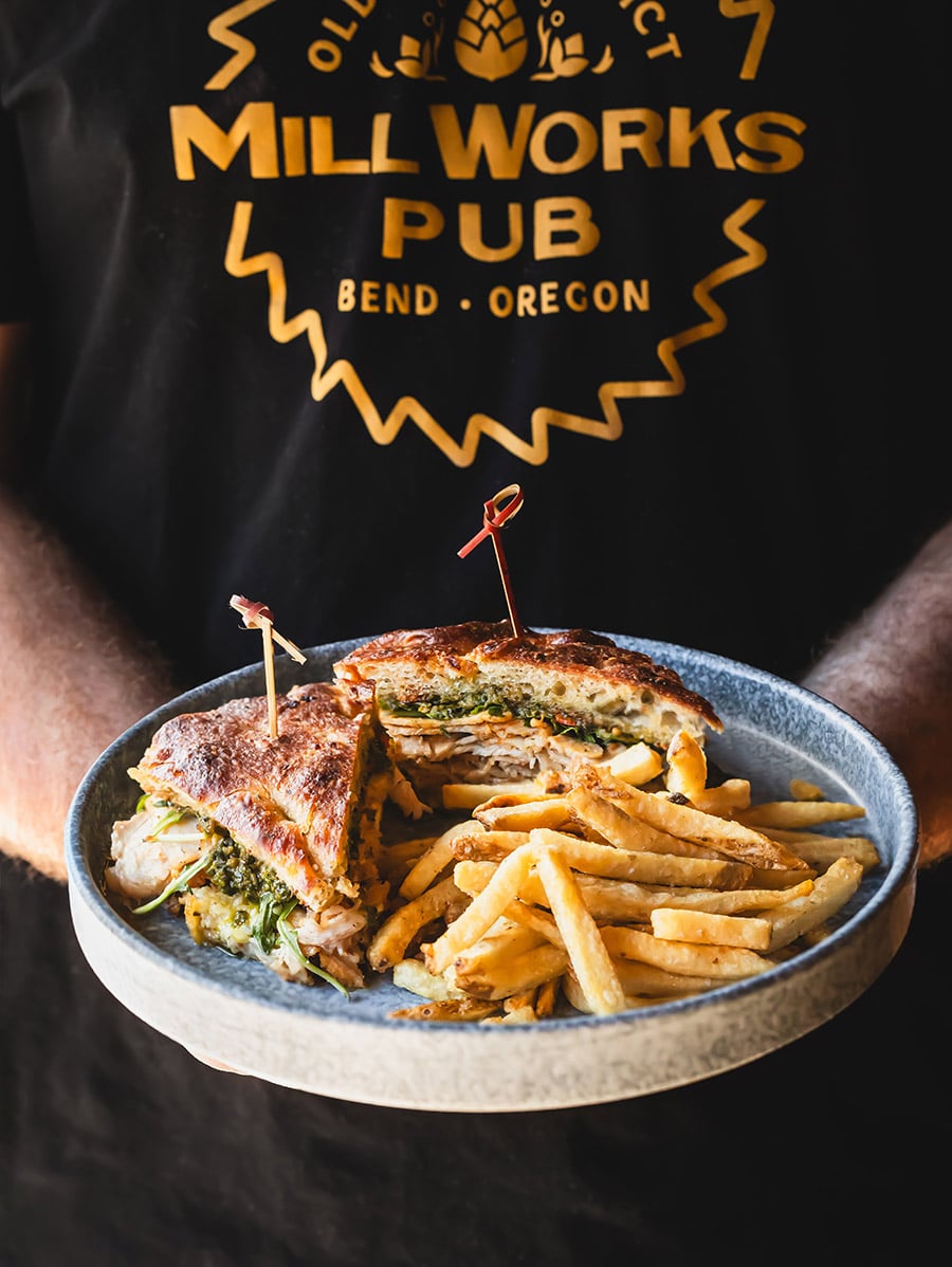 Mill Works Pub employee holding sandwich plate