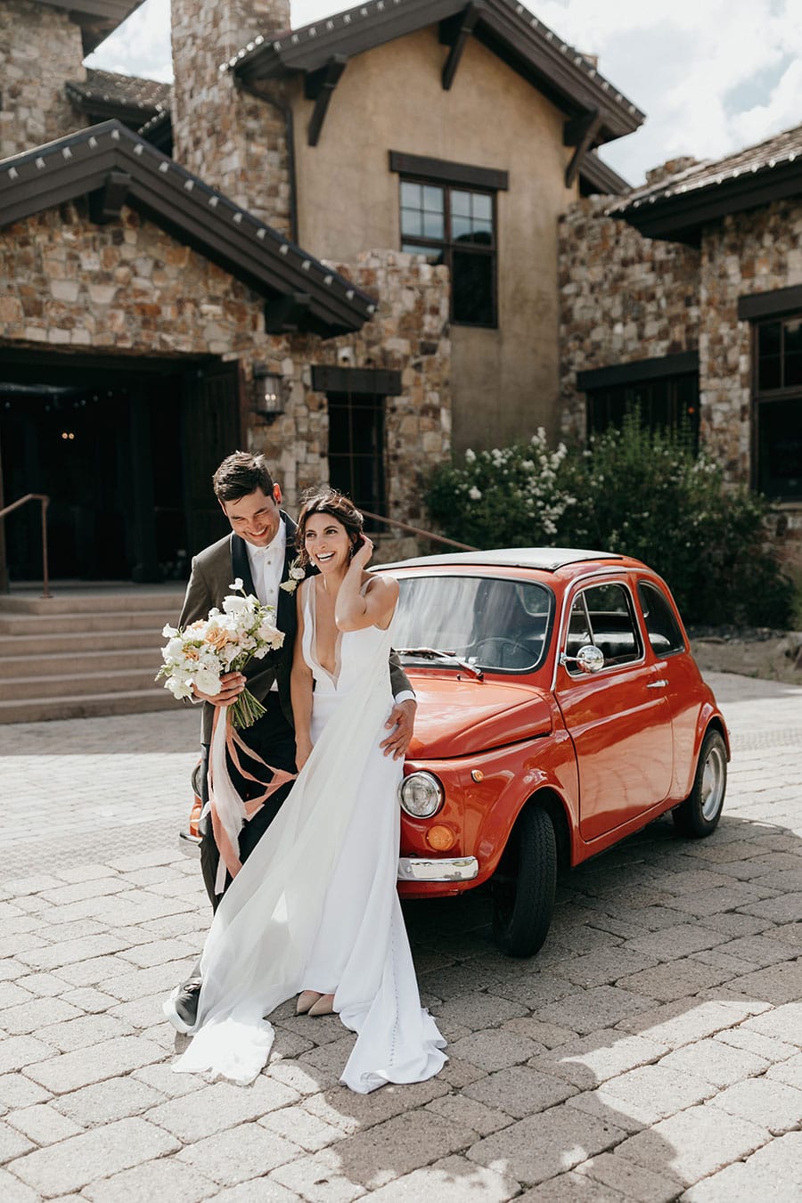 Wedding couple leaning against Fiat