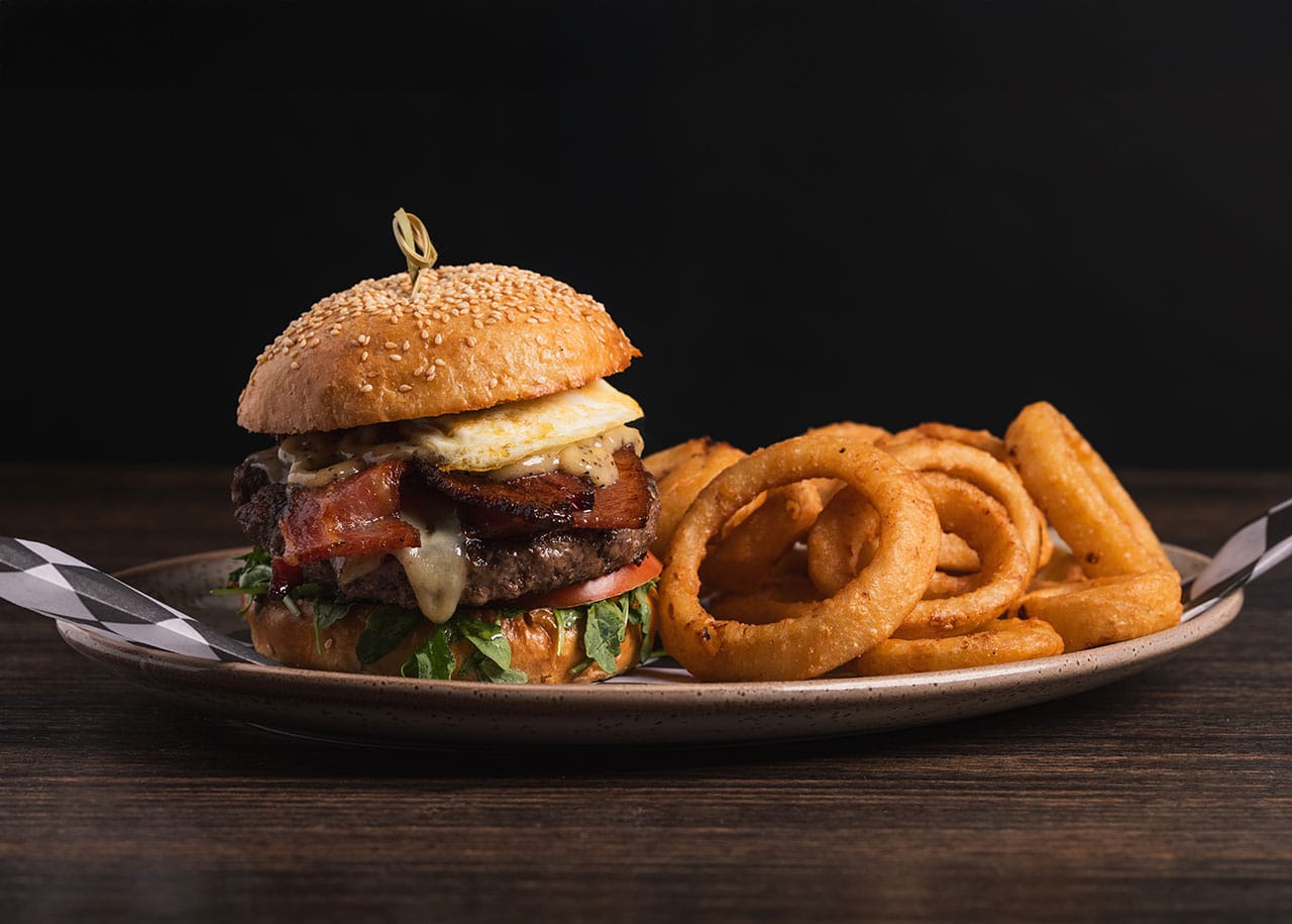 Burger and onion rings on plate from Brand44