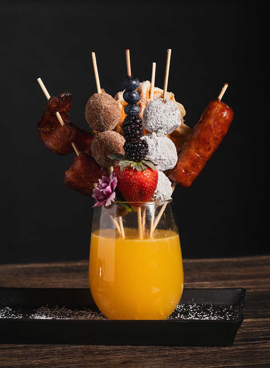Orange drink with skewers of food stinking out of it from Brand44
