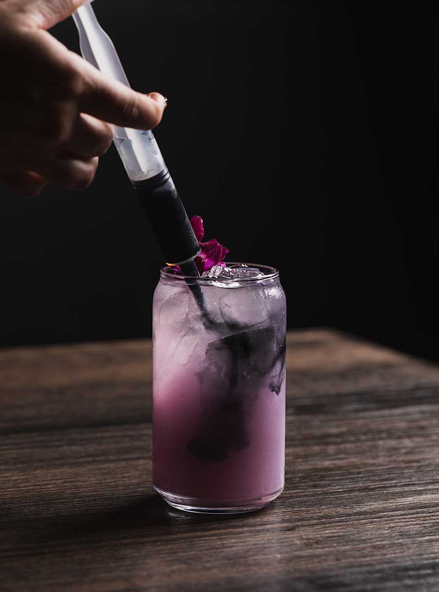 Cold drink getting infused with purple liquid from Brand44