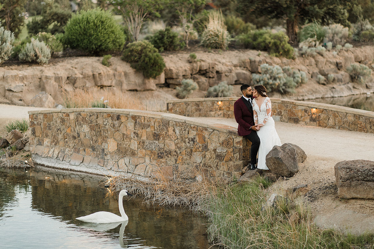 Wedding couple kissing by water at Juniper Preserve