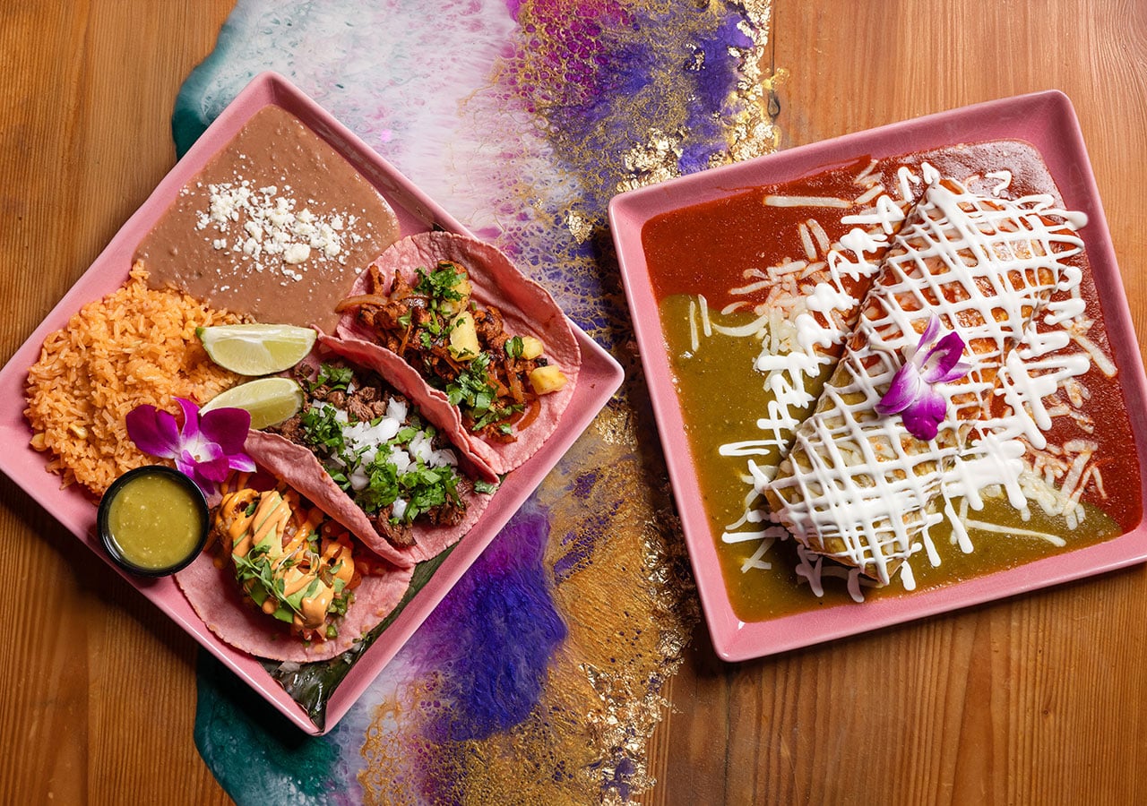 tacos and smothered burrito on pink plates La Catrina