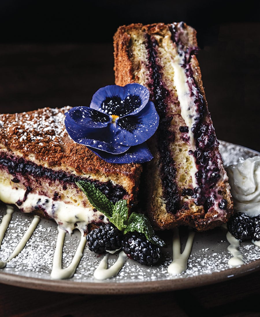 Marionberry French Toast plated beautifully with purple edible flower on top at Brand 44