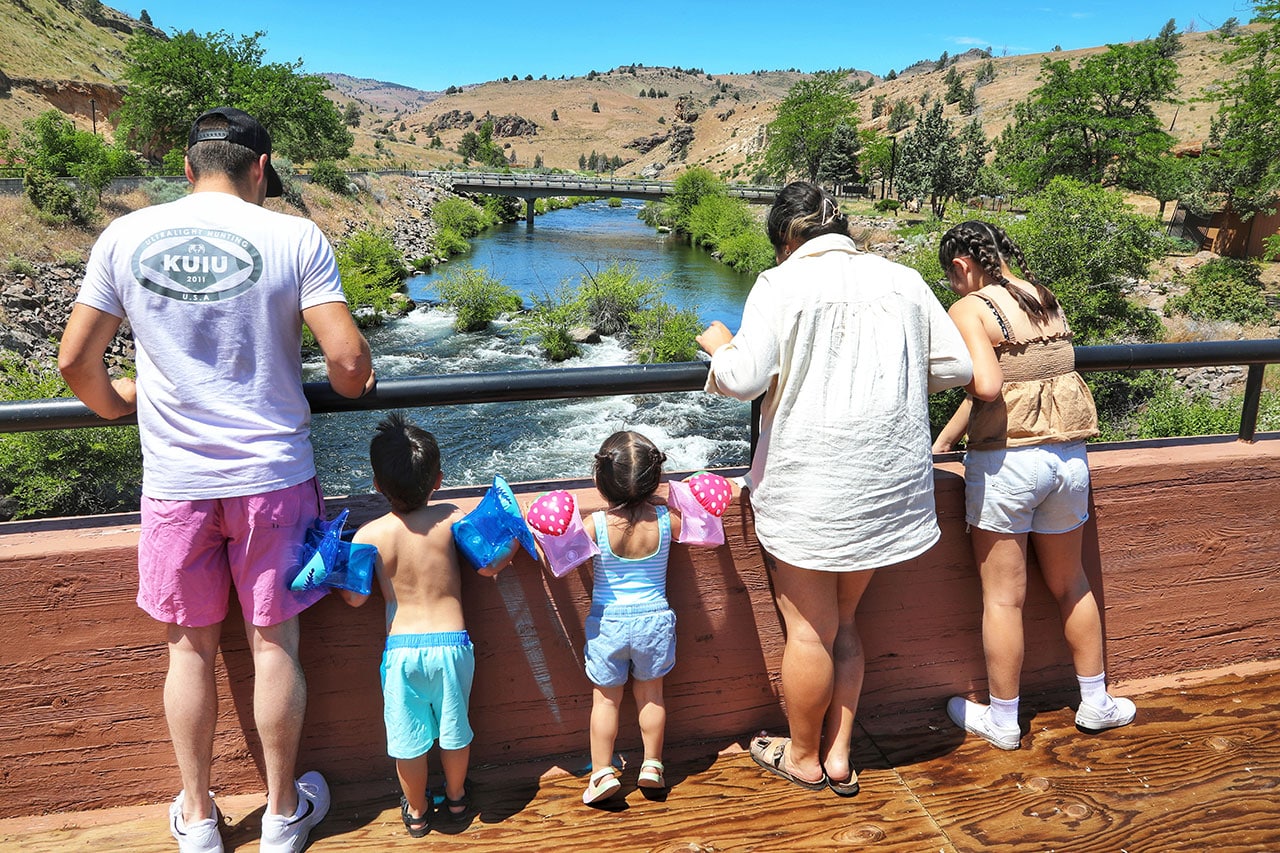 Family standing on bridge looking at the Deschutes River in Kah-Nee-Ta