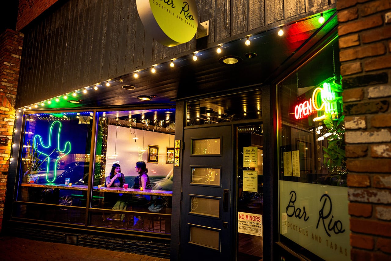 Entering Bar Rio downtown Bend with people enjoying cocktails in the window