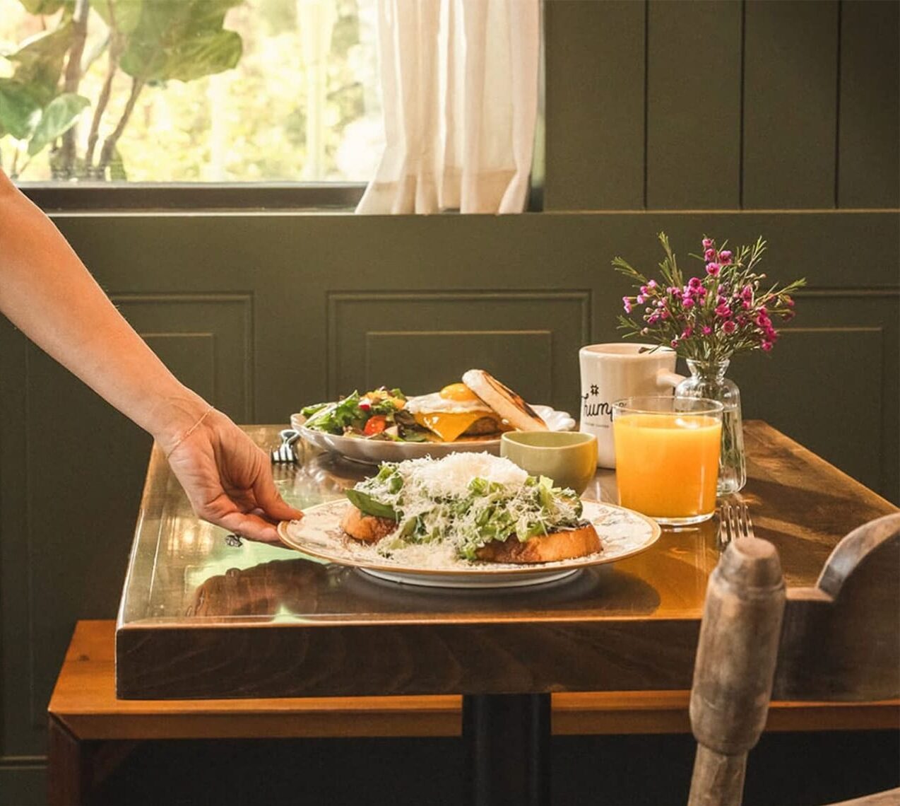 Woman serving breakfast at 8 am at Dear Mom Cafe