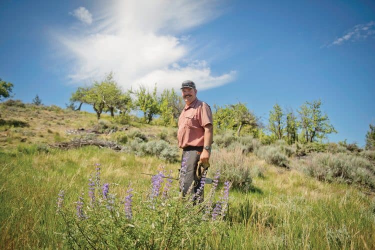 Matt Cyrus standing in the orchard in Central Oregon