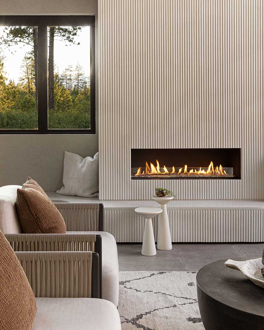 Outdoor inset fireplace with chairs and rug tetherow