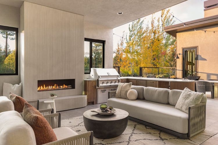 Tetherow home cozy patio in fall with fireplace, couch and rug