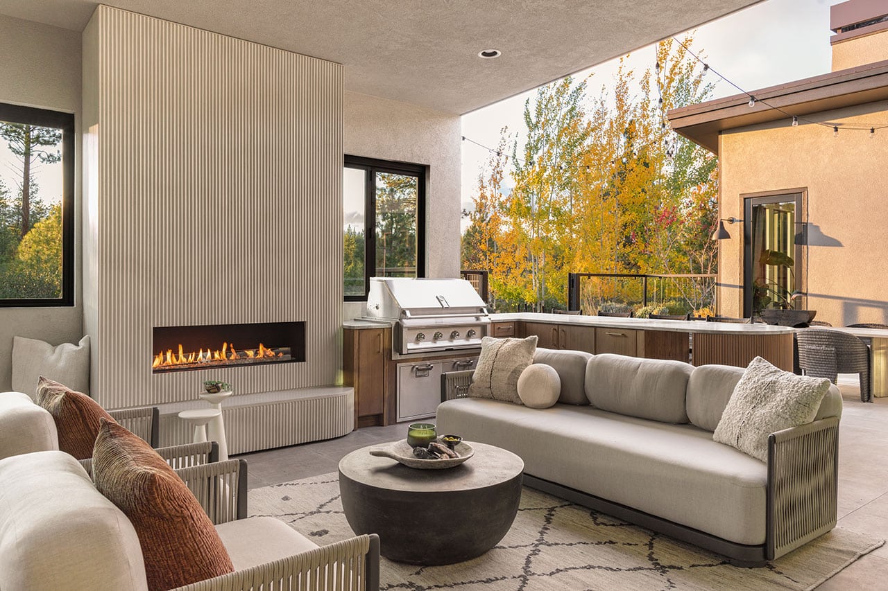 Tetherow home cozy patio in fall with fireplace, couch and rug
