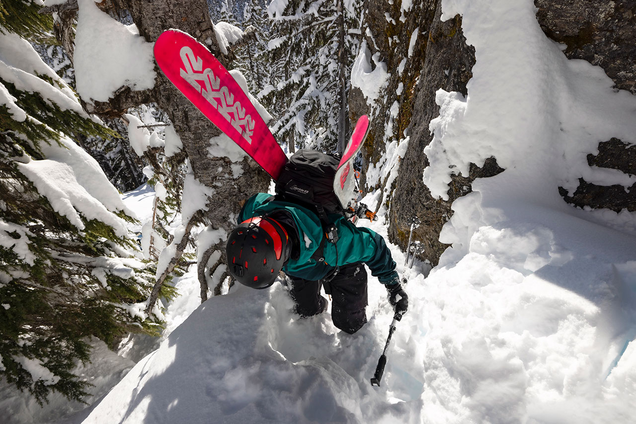 backcountry skier climbing up snowy steep mountain