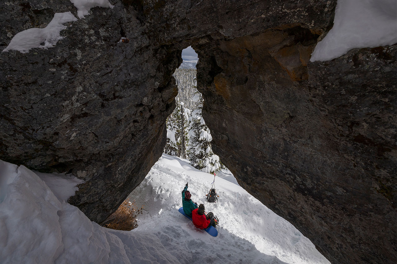 backcountry skiers climbing up snowy steep mountain