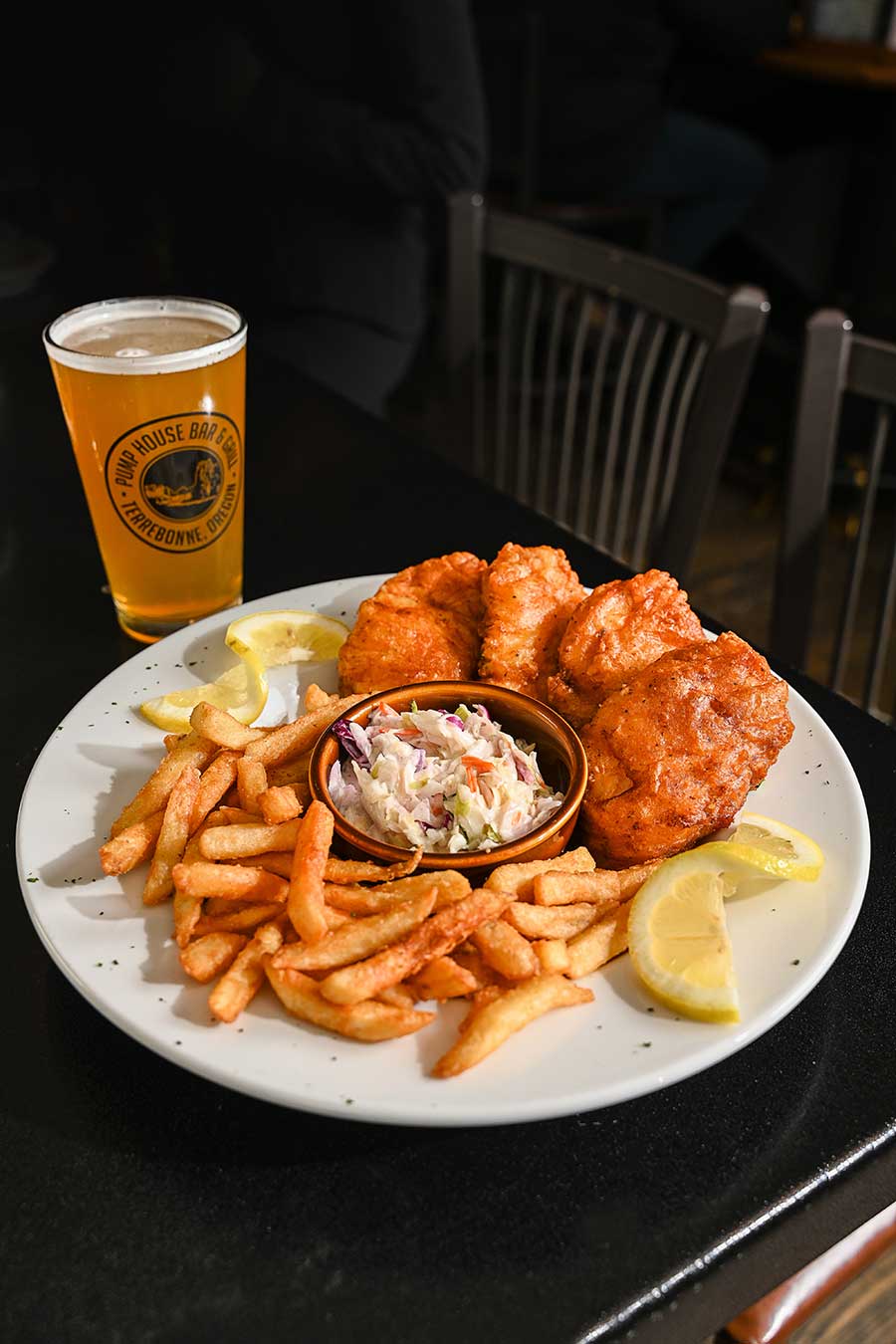 Fish and chips on a plate with pint of beer from Pump House Bar and Grill