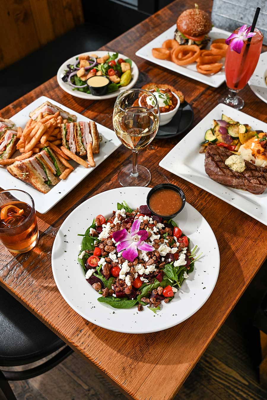 Salads and other entrees on table from Pump House Bar and Grill