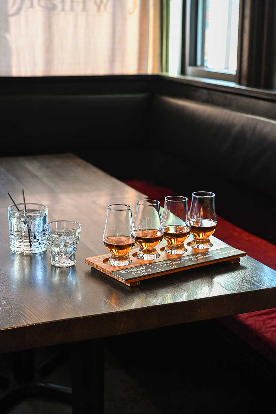 Whiskey flight on table at booth at Stihl Whiskey Bar