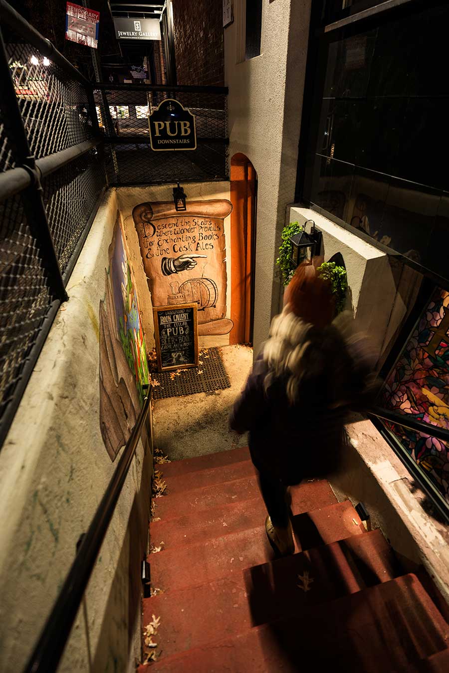 Person walking down stairs to underground book gallery in Bend