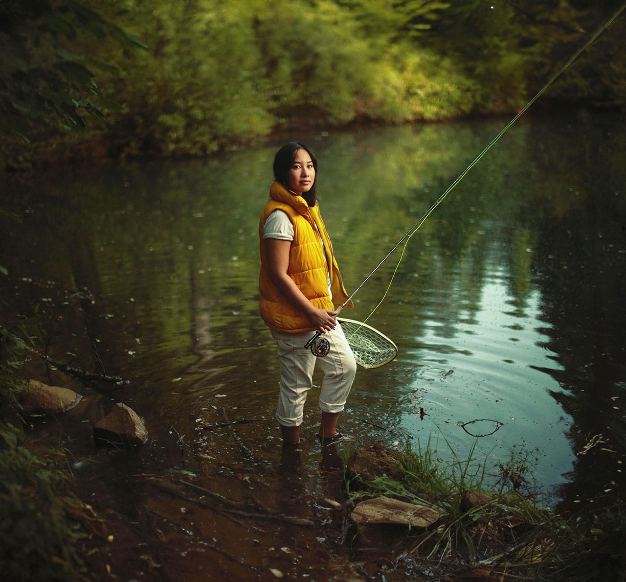 Anna Le stands in water fly fishing