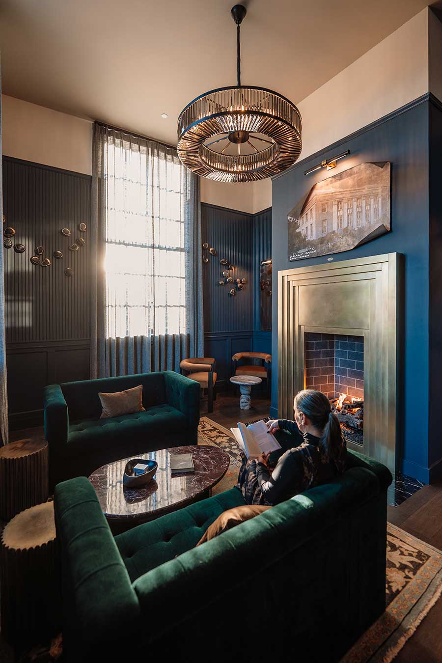 Woman reading by fire inside the westman lounge