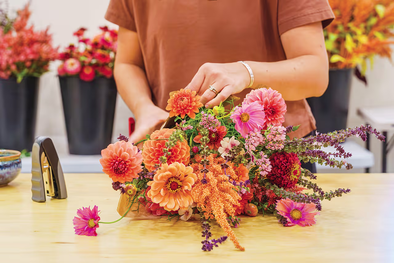 Eliza Eaton of Roots Wild Floral putting together a bouquet
