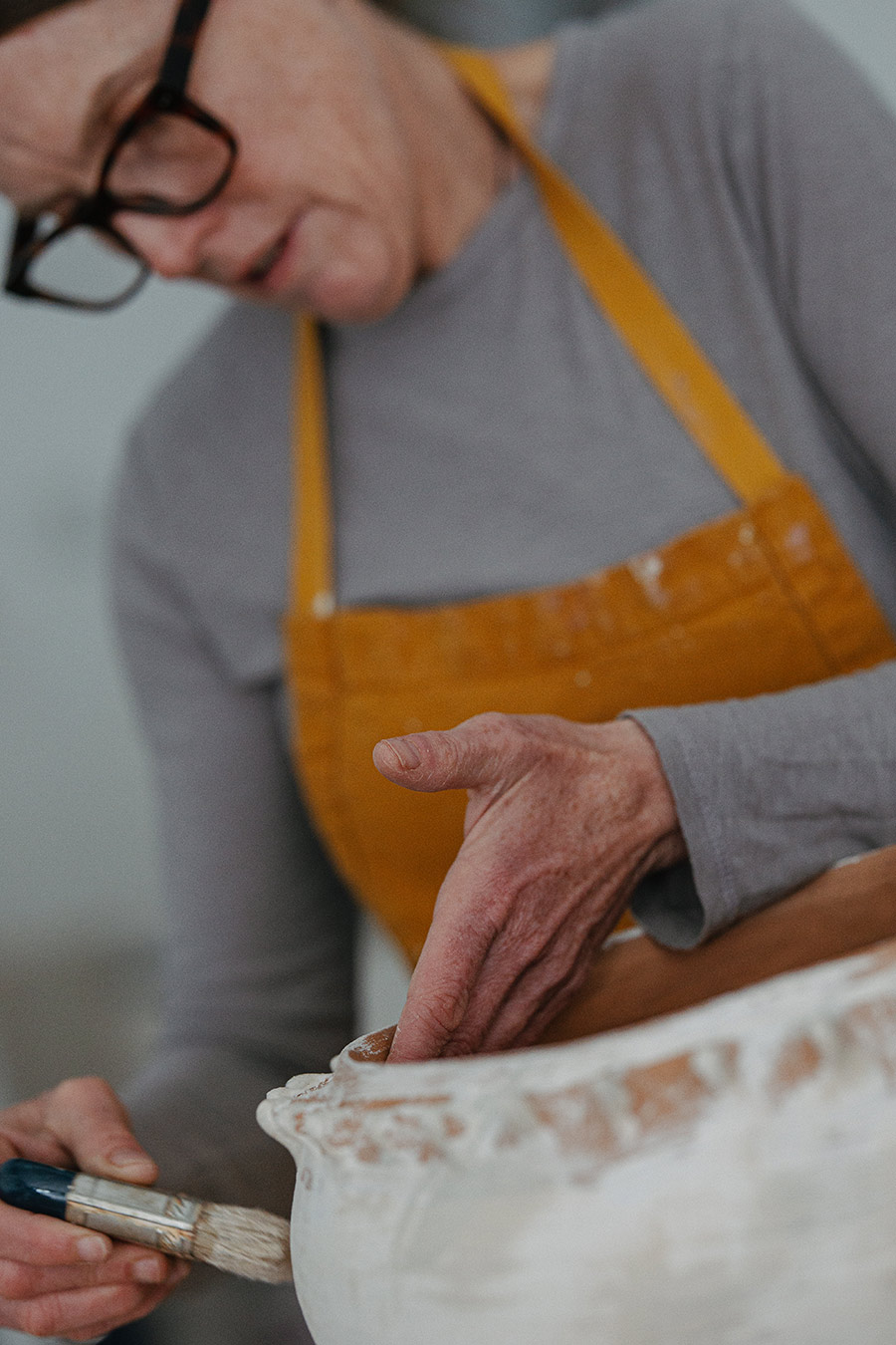Heidi Weiss Hoffman painting a ceramic bowl
