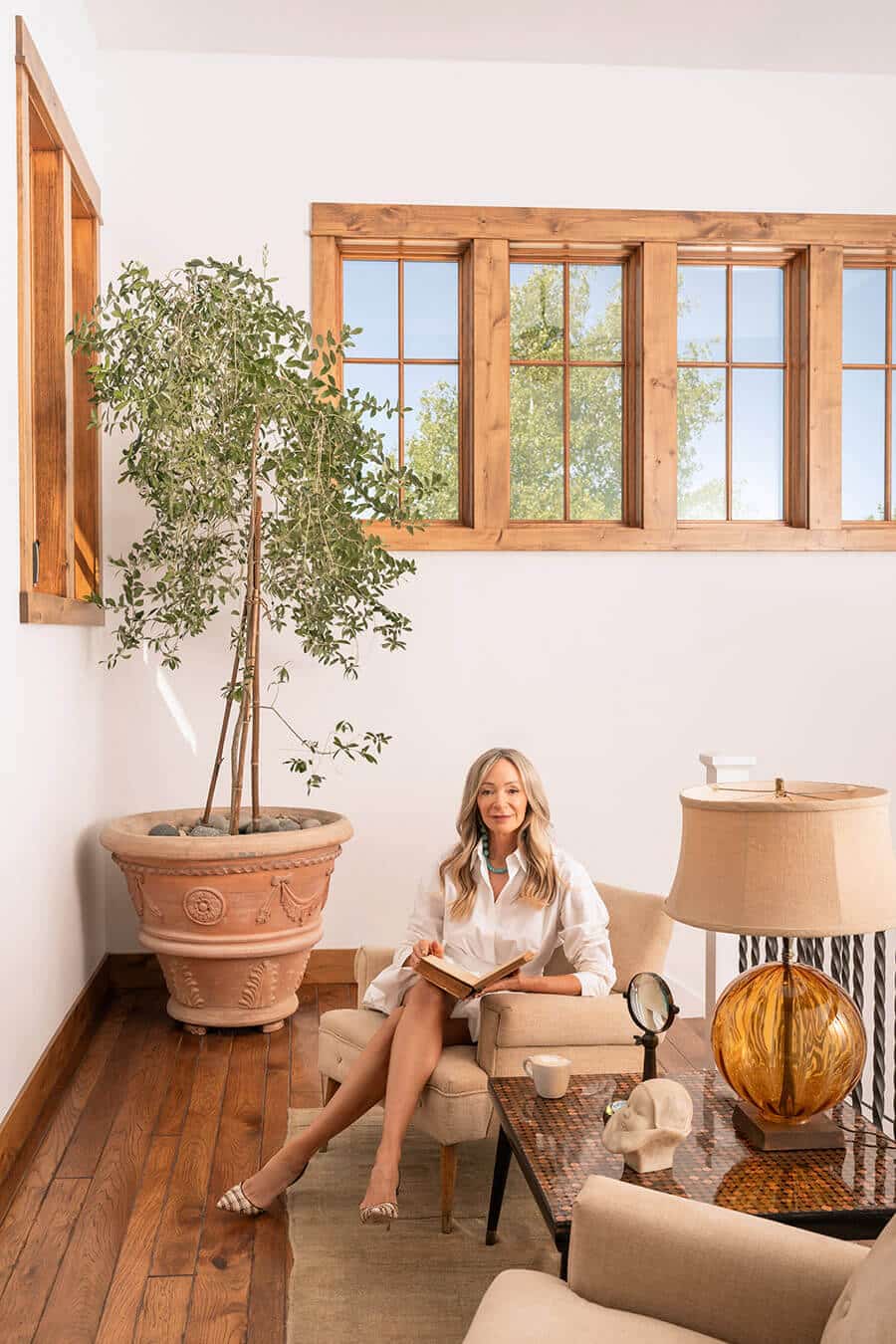 Kristin sitting in chair next to olive tree