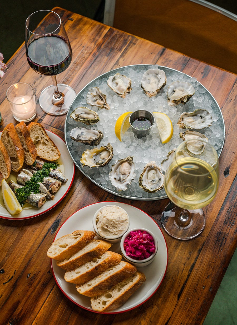 Oysters, wine, bread on table at Olvi in Bend
