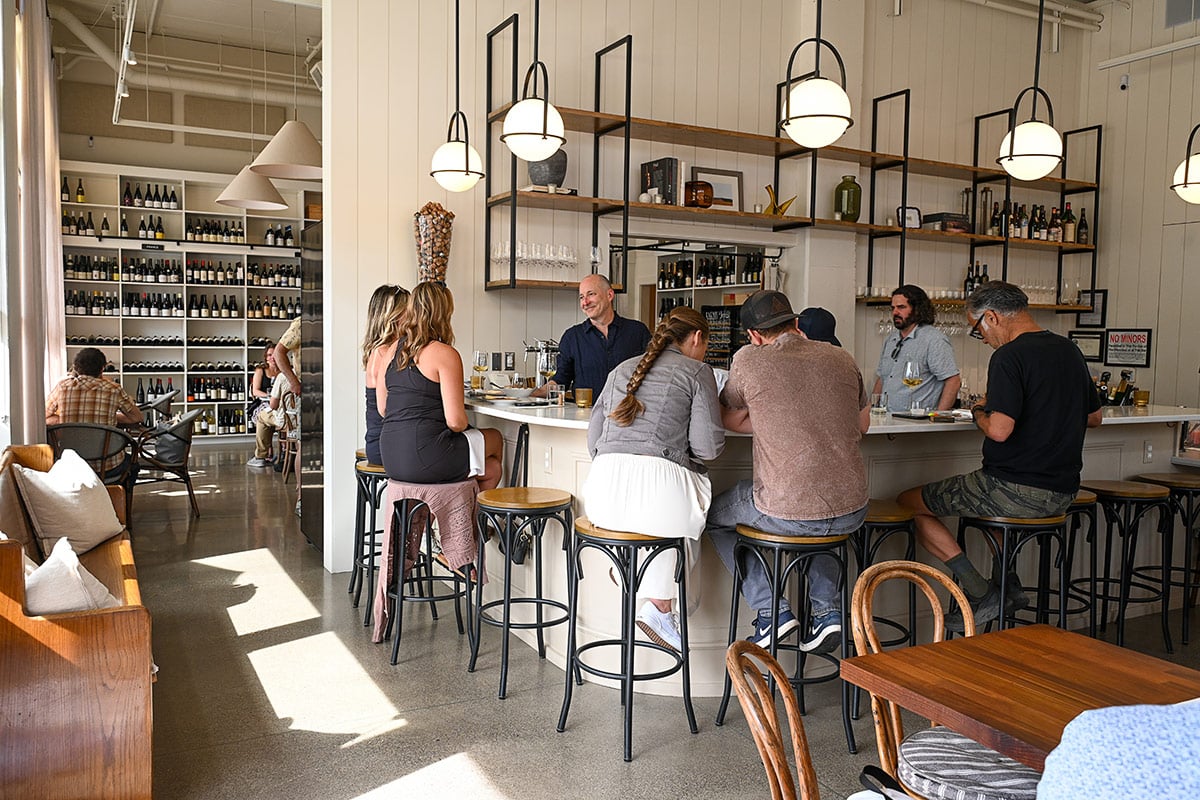 People sitting at bar inside Viaggio Wine Merchant