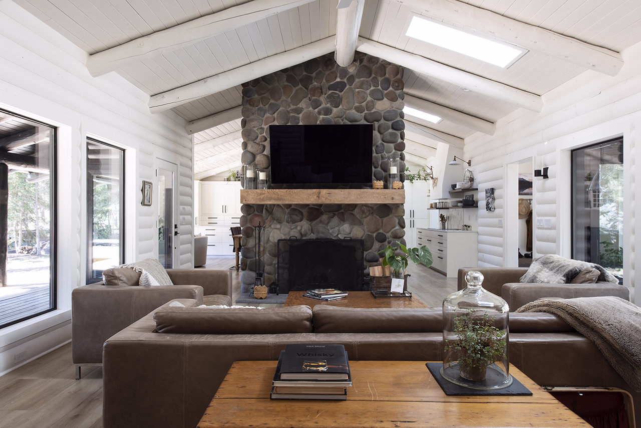 A white Scandinavian-inspired living room with a stone fireplace.
