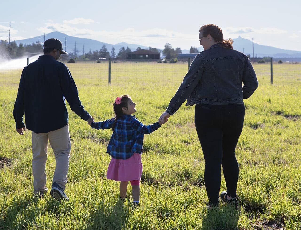 Family walking across Cascade Mountain Pastures in Sisters