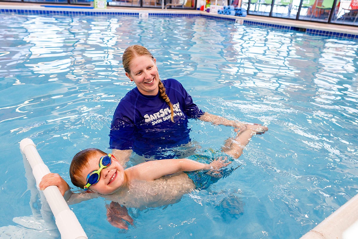 Swim instructor at SafeSplash in Bend giving a swim lesson to a young boy