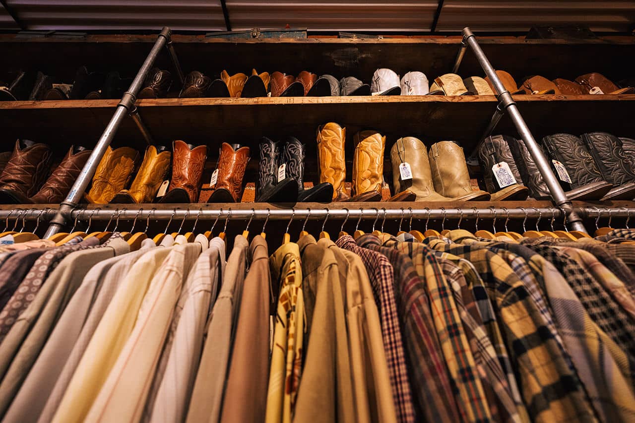 cowboy boots and shirts lined up by color at Old Boy Vintage