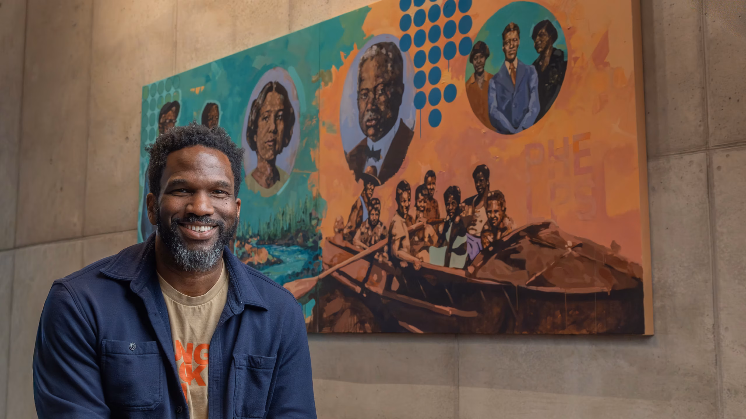 Jeremy Okai Davis in front of his artwork in the Central Library